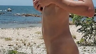 Sexy shemale exhibitionist strokes big uncut cock on beach